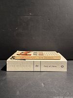 Side view of both paperback novels stacked