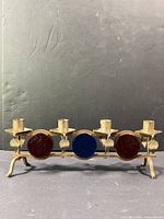 Front view showing four candle cups, three colored glass discs, and full width
