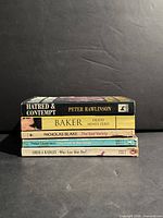 Stack of five paperback novels showing spines