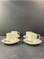 Four teacups each on a saucer showing pattern
