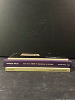 Three art books stacked showing spines