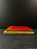 Side view of both books stacked, showing spine of French Paintings III and top board colour gradient of French Art volume