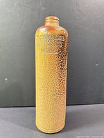 Full view of mottled brown stoneware bottle showing size and form