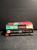 Stack of three paperback novels showing spines