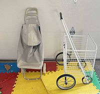 Grey fabric shopping trolley and white wire basket cart side by side