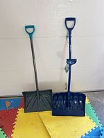Front view of both shovels upright on floor mats