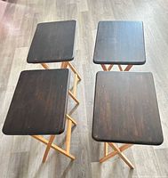 Set of four folding TV trays standing upright