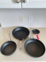 Four frying pans laid out showing size range