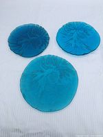 Three blue glass plates laid out to show full set