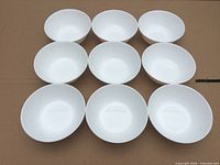 Top-down view of nine identical white bowls