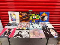 All 12 album covers laid out on table