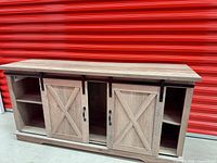 Front view showing overall cabinet, sliding barn doors, side shelves, black metal track
