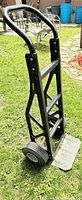 Front view of black polymer hand truck showing frame, wheels and toe plate