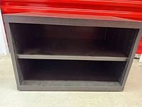 Front view of dark espresso IKEA BESTÅ open shelving unit with adjustable shelf installed