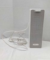 Front view of speaker with attached power cord visible