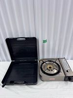 Stove and open carrying case on table