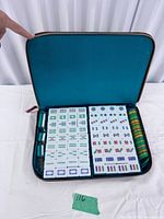 Open carry case showing mahjong tiles, racks, chips, dice and teal interior