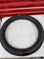 Full view of the black Mantra Sports fitness ring on white surface