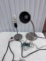 Both brushed metal lamps and butterfly night light on table