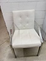 Front view showing white tufted upholstery and chrome arms