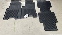 Full set of four black rubber mats laid out