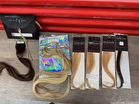 Overview of boxed Each Strand sample, loose extensions, and four sealed Infinitude packs