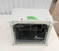 Front view of Ronco Showtime Compact oven showing glass door, interior spit and rack
