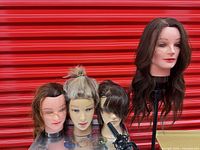 Four mannequin heads with varied hair, clamp stand and curling wand