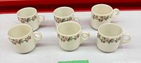 Six Apple Blossom cups arranged rim up displaying pattern