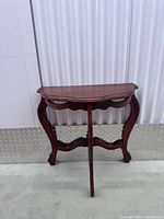 Front view of demi-lune mahogany console table