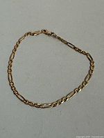 Entire 10K gold Figaro bracelet laid flat