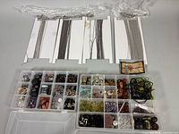 Lot overview showing two organizers filled with beads and findings, four chain cards at top