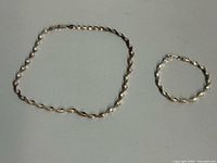 Choker and bracelet laid flat showing full lengths and twist pattern