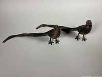 Both bronze-tone metal pheasant figures side by side