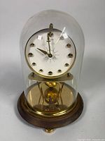 Full view of Kaiser 400-day clock under glass dome on wood/brass base