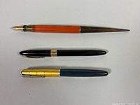 Three pens laid out to show overall design and relative sizes