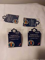 Four sealed Toronto Maple Leafs medallions on backing cards