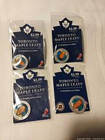 Four sealed Toronto Maple Leafs medallions in original packaging
