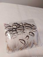 Front view of sealed bag showing white feathers with dark striped tips