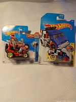 Both sealed Hot Wheels cars side by side on cards