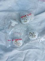 Four packaged ceramic knobs on cloth background