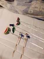 All five swizzle sticks and two sandwich picks laid out on cloth