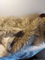 Top view of the shaggy grey-taupe faux fur rug displayed on surface