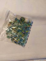 Full bag of assorted marbles on white background