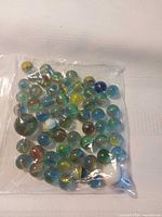 Front view of sealed bag showing assortment of glass marbles