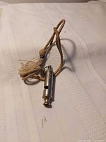 Full view of whistle with lanyard on fabric surface