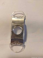 Front view of cigar cutter showing stainless steel blades and clear acrylic handles