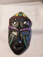 Front view of composite mask showing multicolour paint and cut-outs