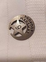 Front view of Provost Marshal badge showing lettering, star cutout, number 9