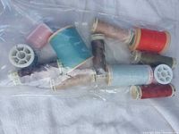 Bag containing assorted coloured thread spools